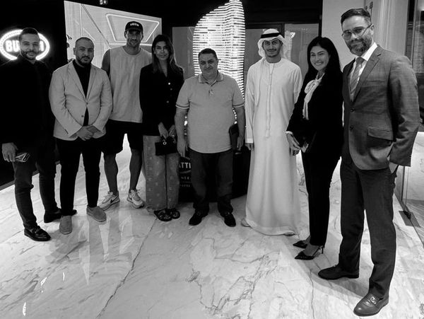 Group of diverse professionals posing together indoors on a marble floor.
